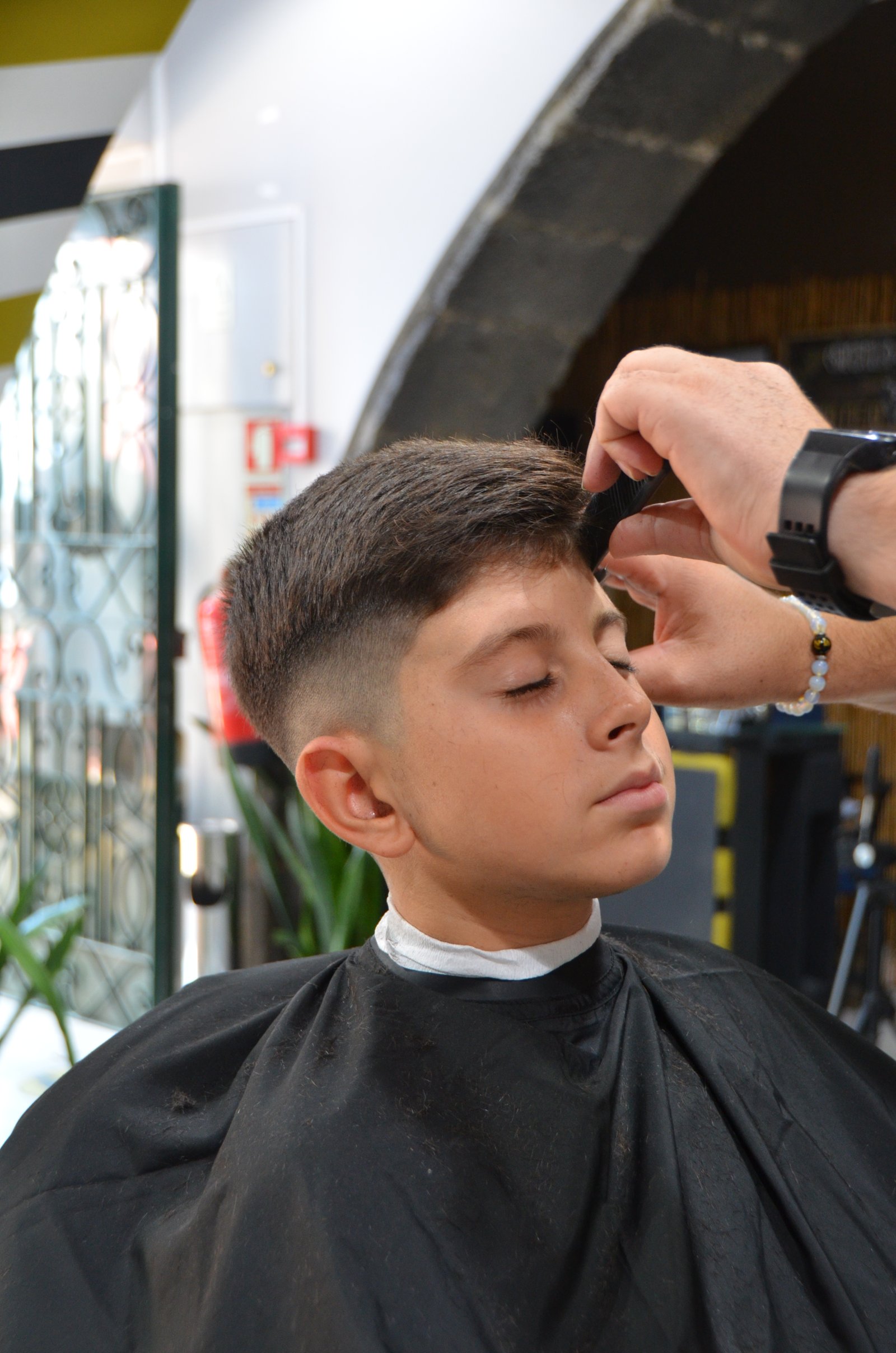 Barbeiro a executar corte de cabelo